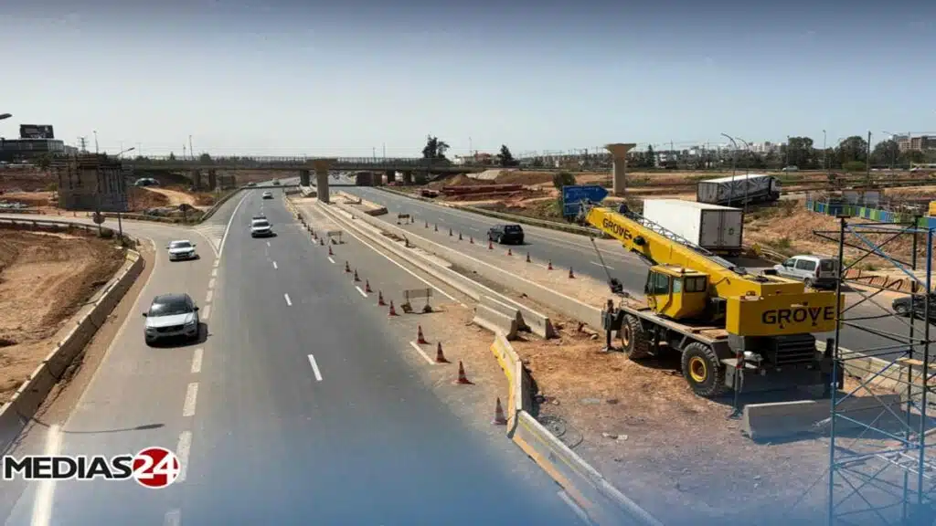 Vue de l’autoroute de contournement de Casablanca au niveau de Sidi Maarouf avec circulation et engins de chantier.